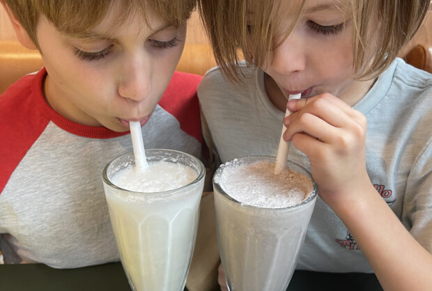 Kids drinking milkshakes at Happy Face Pizza, King's Cross